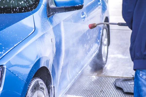 Lavado manual del coche con agua a presión en el lavado del coche exterior.Limpieza del coche con agua de alta presión . — Foto de Stock