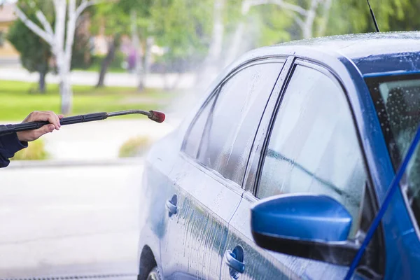 Lavado manual del coche con agua a presión en el lavado del coche exterior.Limpieza del coche con agua de alta presión . — Foto de Stock