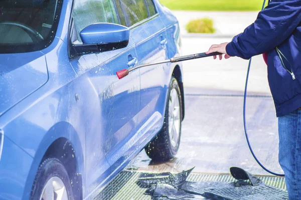 Lavado manual del coche con agua a presión en el lavado del coche exterior.Limpieza del coche con agua de alta presión . — Foto de Stock