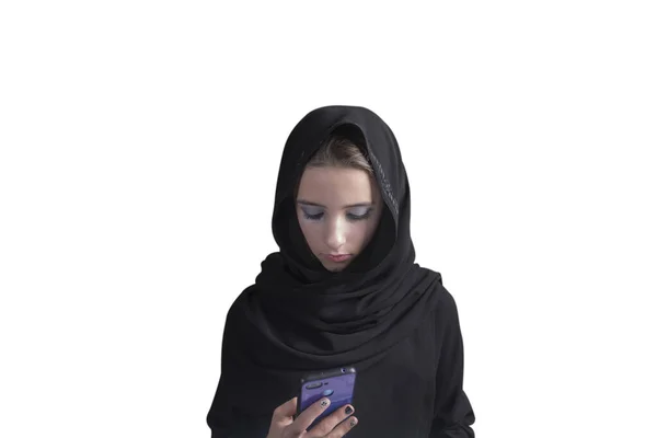 Fille arabe en abaya noir et fond blanc avec un téléphone dans ses mains. musulmane arabe fille . — Photo