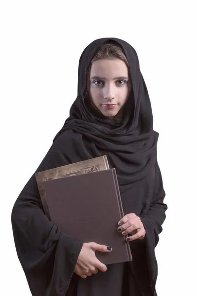 Arabische Studentin trägt Hijab und hält ein Buch mit weißem Hintergrund. Arabisches Mädchen in schwarzer Abaya mit Büchern. Muslimisch arabisches Mädchen. — Stockfoto