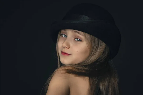 Menina em um chapéu preto e contas brancas.Retrato de uma menina bonita em estilo retro em um chapéu preto elegante no fundo preto . — Fotografia de Stock