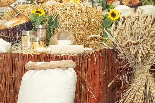 Espiguillas de trigo espinoso junto a los platos. Hornear el concepto de pan Harina de trigo en bolsas junto a espiguillas de trigo . —  Fotos de Stock