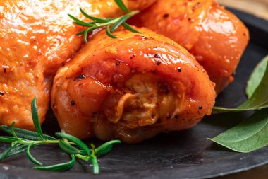 Chicken legs in a red marinade on a cooking board. Pickled raw meat. Dietary meat. Cooking.Raw marinated chicken legs for grill and bbq