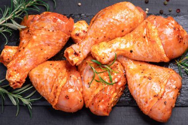 Chicken legs in a red marinade on a cooking board. Pickled raw meat. Raw marinated chicken legs for grill and bbq.Dietary meat. Cooking.