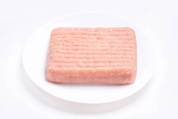 Raw chicken mince on a white plate and on a white background.Isolate. Close-up of chicken mince. Delicious diet meat. — 图库照片