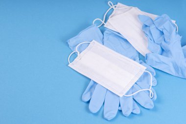Coronovirus, covid -19. Mavi arka planda mavi eldivenli tıbbi beyaz maske. Sağlık ve koronavirüs, karantina ve kişisel koruma eksikliği. Koronovirüs ve diğer bulaşıcı hastalıklarla mücadele kavramı..