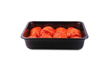 Izgara bacak. İzole edilmiş. Çiğ tavuk salamura edilmiş bacakları beyaz arka planda siyah plastik bir paketin içinde. Çiğ tavuk marine edilmiş et paketinin içinde..
