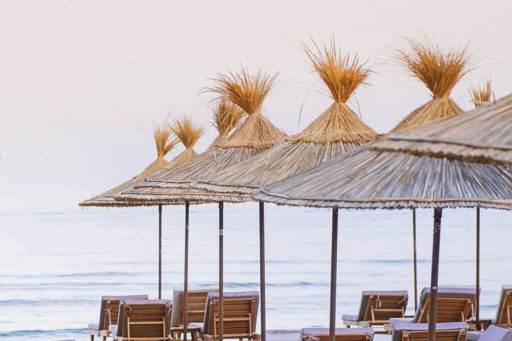 Beach thatched umbrellas on the beach promenade.