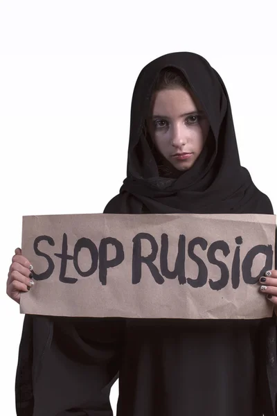 Tradycyjna arabska muzułmanka w stylowej abaji.Arab młoda dziewczyna ze smutną twarzą ubrana w czarną abaja z tekstem w ręku zatrzymać rosyjski. Rosyjski agresor w Syrii. Muzułmanin dziewczyna w czarny abaya. — Zdjęcie stockowe