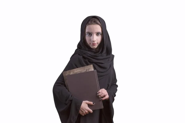 Estudiante árabe vistiendo abaya, sosteniendo libro.. Chica árabe vestida de abaya negra con libros en sus manos, estudiante. Chica musulmana en abaya negra estudiante femenina . — Foto de Stock