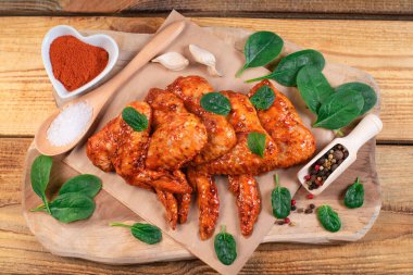 Ahşap arka planda salamurada tavuk kanatları çiğ. Izgara tavuk kanadı tarifi.