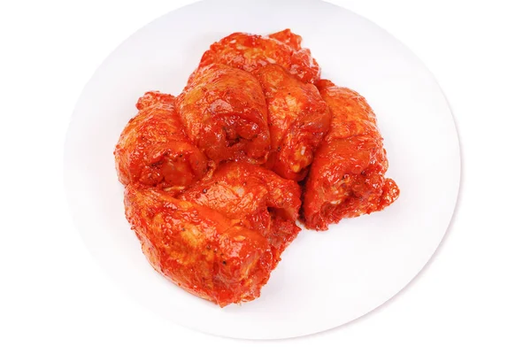 未煮熟的腌鸡大腿 在白盘上的红色腌制鸡腿 孤立的 — 图库照片