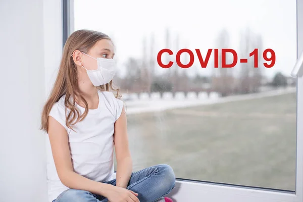 彼女の顔に保護マスクで窓の女の子 通りのコロナウイルスに 伝染病だ 生物工学の概念 ウィンドウ上のテキストCovid ウイルス保護マスク コロナウイルス肺炎Covid — ストック写真