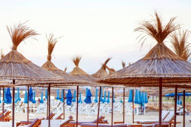 Boş plajlar. Yaz günü sahilde boş iskemleler. Deniz kenarında dinlenmek için boş iskemleler. Deniz kıyısı gezginler için boş güneşlik..