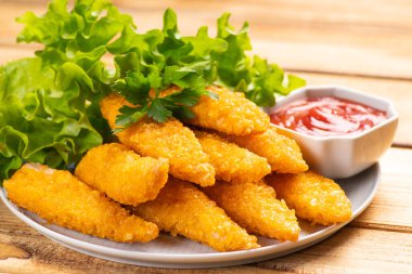 Fast food. Fast food. Fast food. Fesleğen yapraklı tavuk ve ahşap bir masanın üzerinde ketçap. .