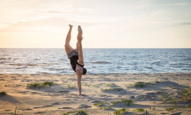 Genç adam Baltık Denizi'nin sahilde spor için gidiyor 