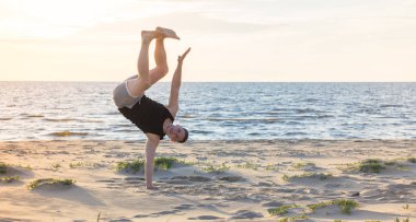 Genç adam Baltık Denizi'nin sahilde spor için gidiyor 