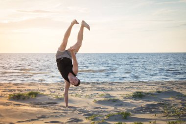 Genç adam Baltık Denizi'nin sahilde spor için gidiyor 