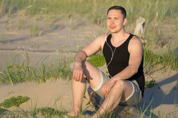 Genç adam Baltık Denizi'nin sahilde spor için gidiyor 