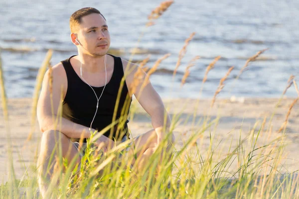 Genç adam Baltık Denizi'nin sahilde spor için gidiyor 