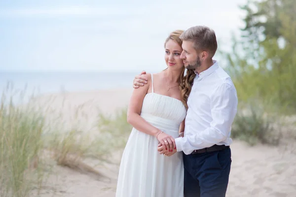 Jovem feliz casal apenas andando de mãos dadas na bea — Fotografia de Stock