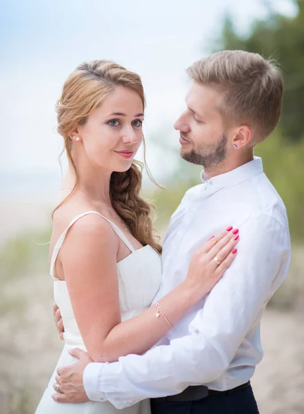 Young happy just married couple walking holding hands on the bea — Stock Photo, Image