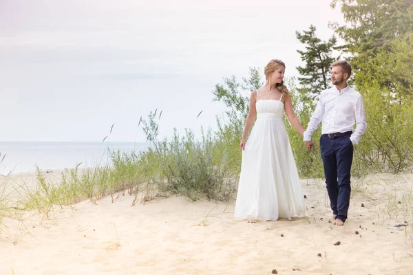 Jovem feliz casal apenas andando de mãos dadas na bea — Fotografia de Stock