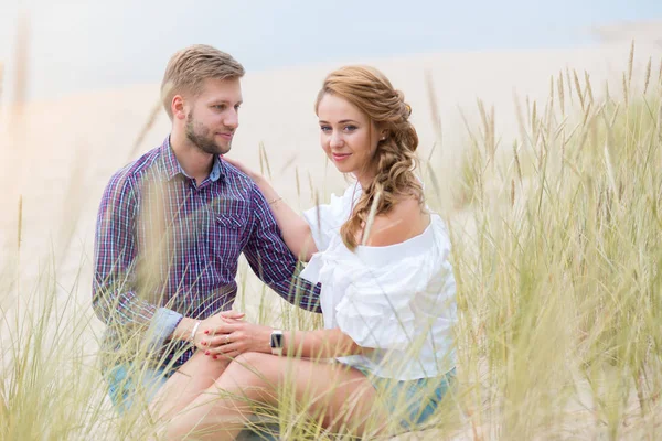 Young family couple having picnic on the beach near the sea, dri — Stock Photo, Image