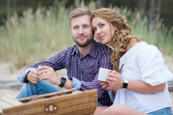 Jonge familie paar hebben picnic op het strand in de buurt van de zee, dri — Stockfoto