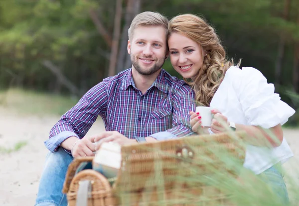 Pareja joven de la familia haciendo picnic en la playa cerca del mar, dri — Foto de Stock