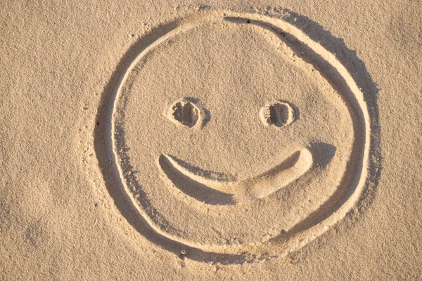Prints of emoji smile in the sand on the beach of the Baltic Sea in summer: summer is almost gone, waiting for autumn.