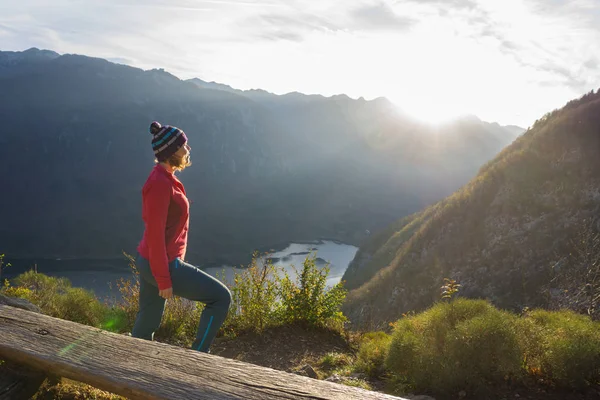 Jeune femme assise sur la branche sur le point de vue, détente arrière — Photo