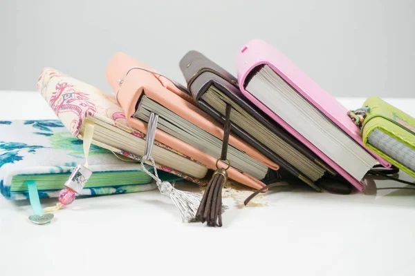 Handmade decorated notebooks and planners of different colors on