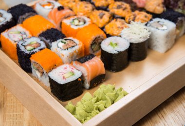 Büyük suşi ve wasabi ile ahşap tepsi üzerinde ayarla rulo