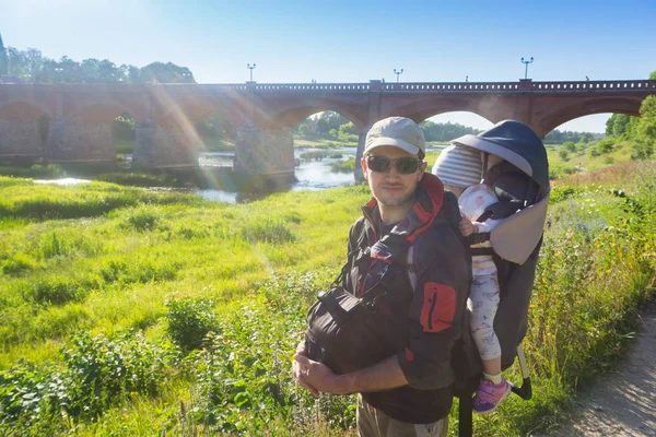 Pai com seu filho em uma mochila viajando e caminhando no summ — Fotografia de Stock