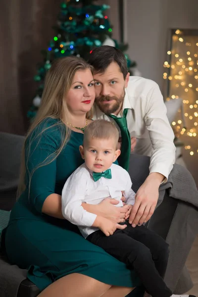 Familia joven con niño en el interior de Navidad con Año Nuevo e — Foto de Stock