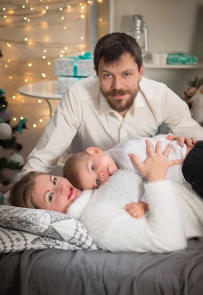Mladá rodina s chlapeček ve vánočním interiéru s Novým rokem e — Stock fotografie
