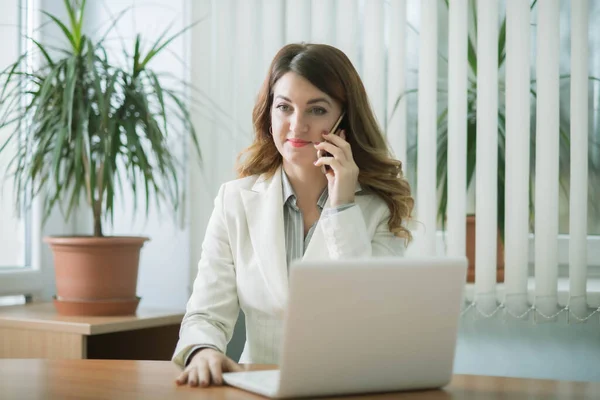 Business woman in company office working on laptop online and communicating remotely