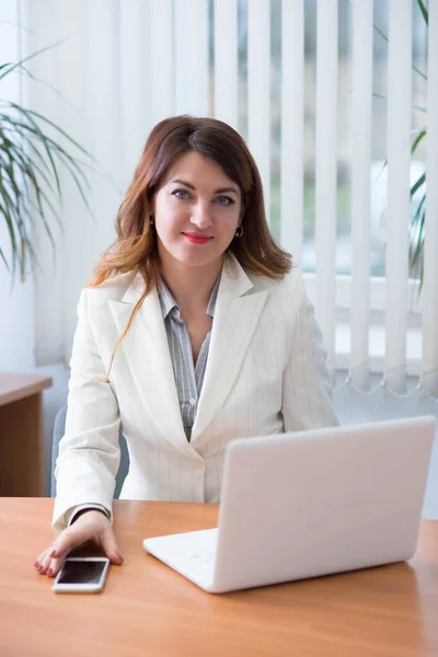 Business woman in company office working on laptop online and communicating remotely
