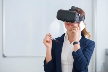 Sanal gerçeklik gözlüklü kadın uzaktan çalıştığı ve ofisini gelecek iş için ustalaştırdığı için.