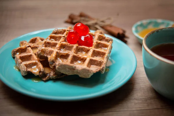 Vegan healthy waffles made in waffle maker with tea, honey and cinnamon