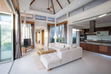 Lüks iç tasarım oturma odası havuzu Villaları içinde. Yüksek yüksek tavan ve ahşap yemek masası ile havadar ve aydınlık alan