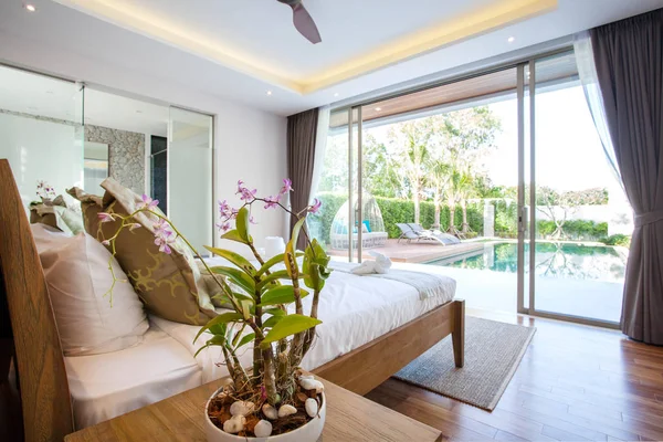 Diseño interior de lujo en el dormitorio de la villa de la piscina con acogedora cama king. Dormitorio con techo elevado — Foto de Stock
