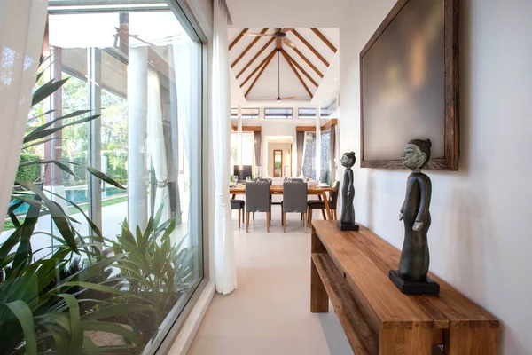 Design d'interni di lusso in soggiorno di ville con piscina. Spazio arioso e luminoso con soffitto alto e tavolo da pranzo in legno — Foto Stock