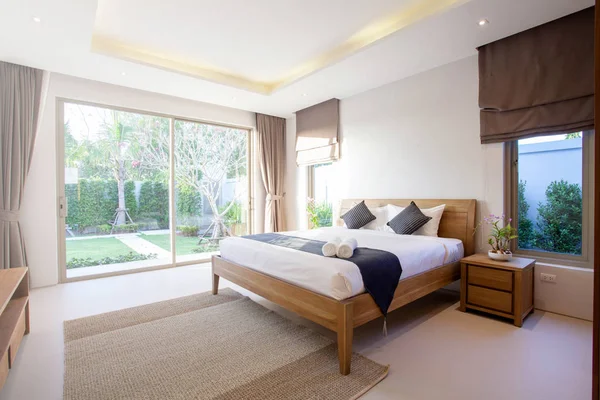 Diseño interior de lujo en el dormitorio de la villa de la piscina con acogedora cama king. Dormitorio con techo elevado — Foto de Stock