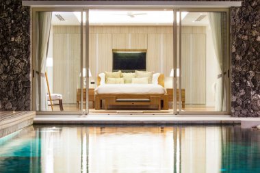 Lüks iç tasarım havuzlu villa ile rahat kral yatak odasında yatak. Yüksek yükseltilmiş tavana yatak odası 