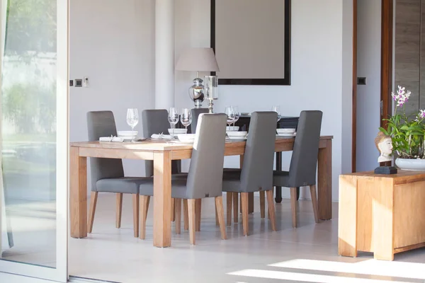 Design de interiores de luxo na sala de estar das moradias da piscina. Espaço arejado e brilhante com teto elevado e mesa de jantar de madeira — Fotografia de Stock