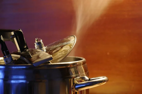 Steam escaping from lid of pressure cooker with reflection of modern kitchen. — Stock Photo, Image