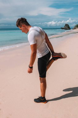 Hint Okyanusu, Endonezya, Bali kıyısında genç kas atlet trenler